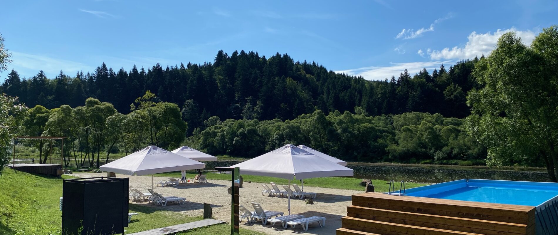 Summer vacation by the water. River beach and outdoor pool in Lviv region.